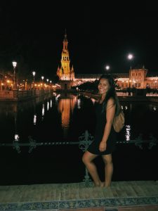 A student standing by a river and a night view in Seville.