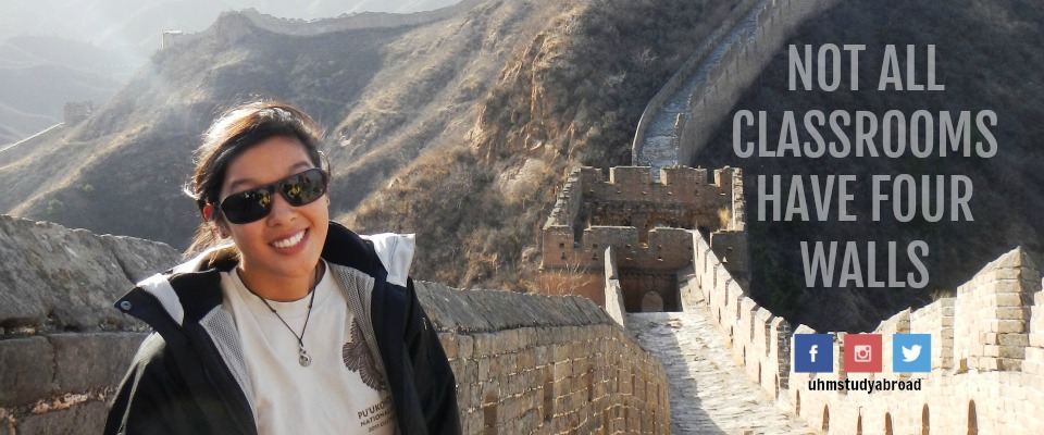 Photograph of a University of Hawaii at Manoa independent study abroad student at the Great Wall of China, with the tagline: Not all classrooms have four walls.