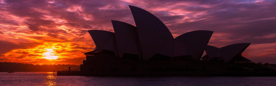Landscape view of the Sydney Opera House at sunset.